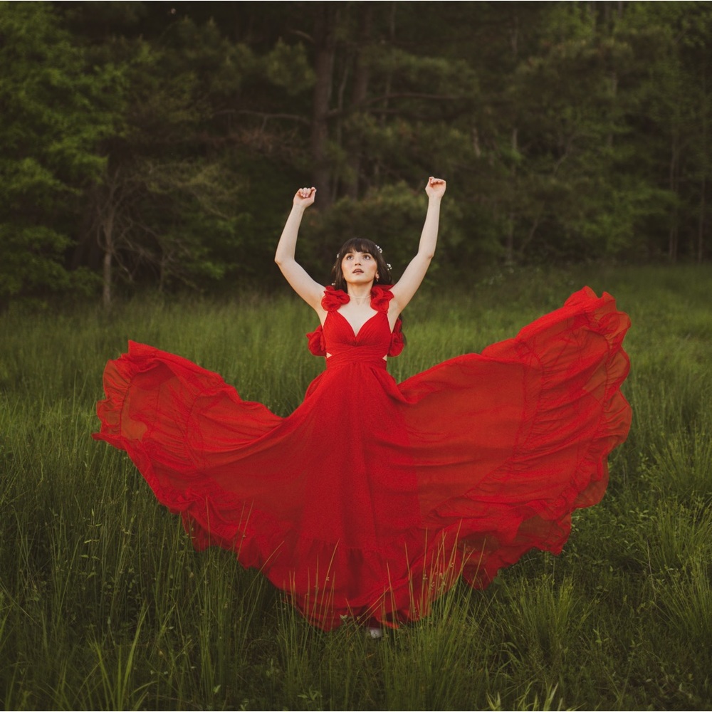 Tiered gown with side cutouts, a lace-up back, and ruffles at the shoulder.